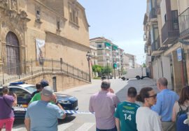 Varias personas observan el trabajo de los agentes tras el cordón de seguridad.