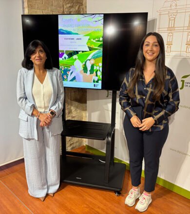 Francisca Medina y María Dolores Ruiz junto al cartel de estas jornadas organizadas por Diputación