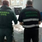 Agente de la Guardia Civil, con el pescado incautado. JUNTA DE ANDALUCÍA