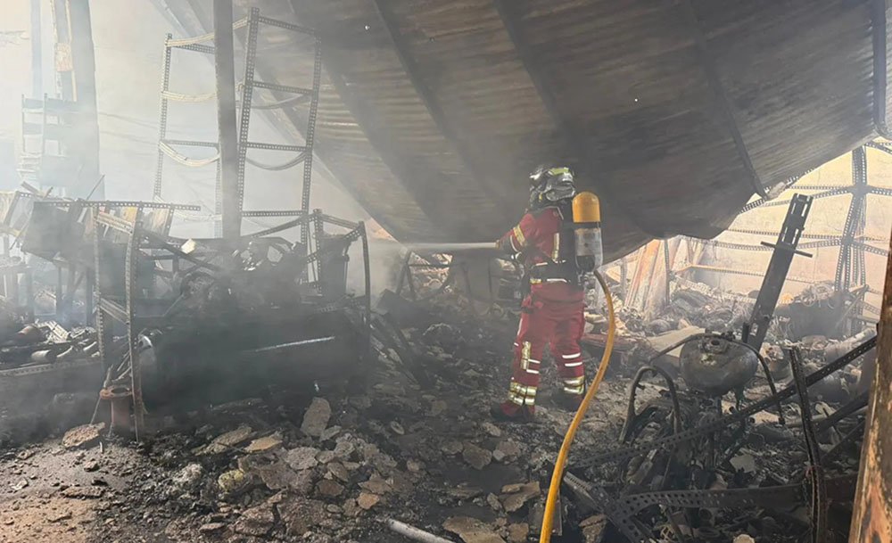 Bombero trabajando en el interior de una de las naves.